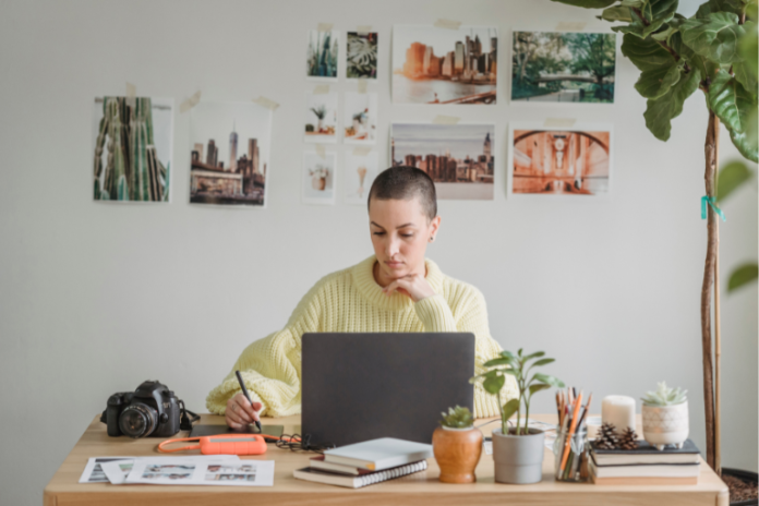 Graphic designer brainstorming ideas for passive income for graphic designers, working with a laptop and design software.