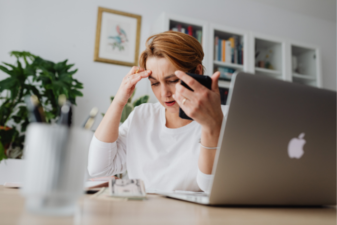 Woman sat at laptop worried about amateur blogging mistakes